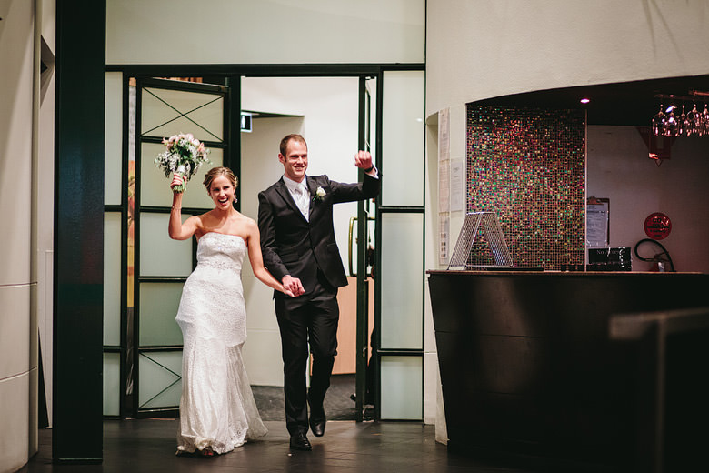 bride and groom celebrate entrance to wedding reception